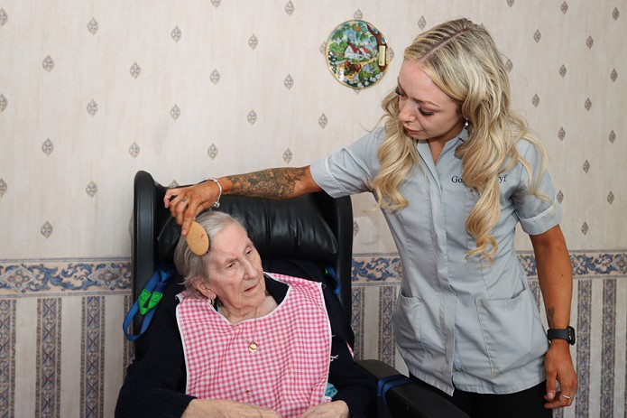carer brushing a womans hair